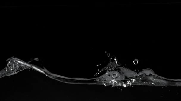 Szuper lassított mozgású fröccsenő víz elszigetelt fekete háttérrel. Nagysebességű mozi kamera, 1000 fps. - Felvétel, videó