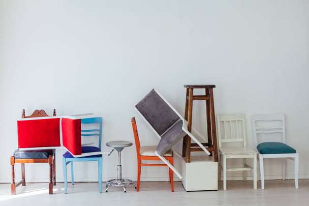 mnoho pestrobarevných židlí stojí v bílém pokoji - Fotografie, Obrázek