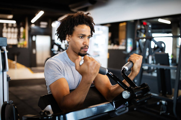 Young fit athlete man working out in the gym - Photo, Image