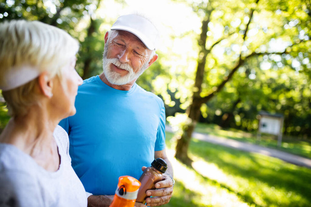 Beautiful senior couple jogging in nature living healthy - Photo, image