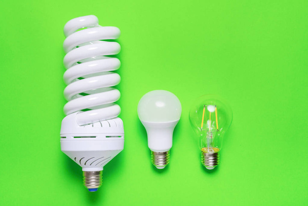 Set of different energy saving lamp on green background - Foto, afbeelding
