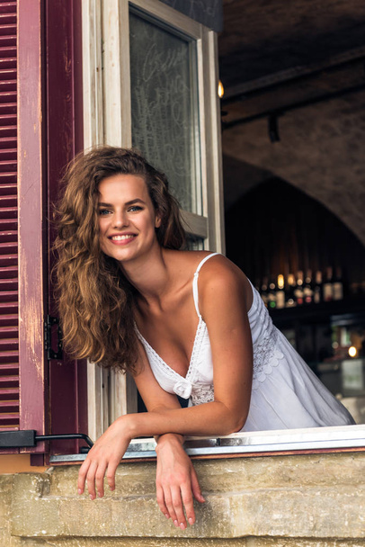 Mujer sonriente en el café mirando por la ventana
 - Foto, Imagen
