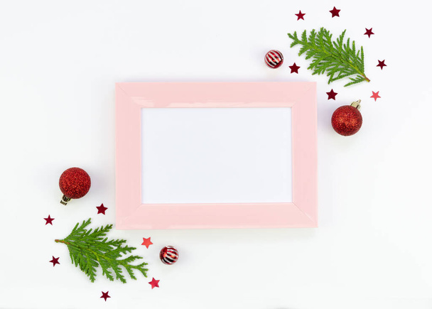 Top view pink Christmas plastic photo frame mock up with copy space and xmas decorations on a white background - Photo, Image