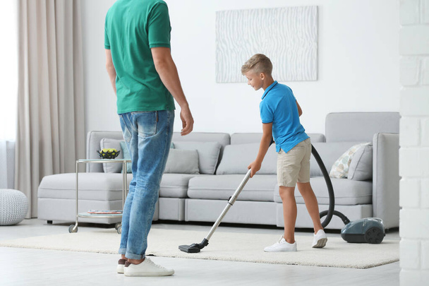 Dad and son cleaning living room together - Foto, imagen