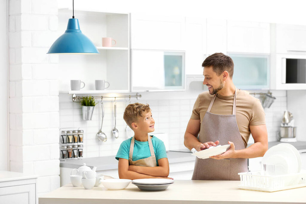 Pai e filho limpando pratos na cozinha
 - Foto, Imagem