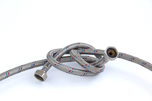 The water inlet hose tap metal braid, tied in a knot isolated on whit - Foto, imagen