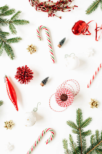 Christmas / New Year composition with fir branches, Christmas baubles, sweets, decorations on white background. Flat lay, top view colorful festive holiday concept. - Φωτογραφία, εικόνα