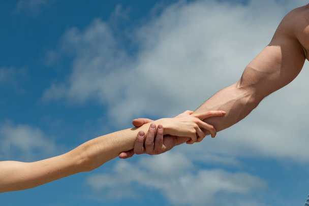 Hände. weibliche und männliche Hand gegen den Himmel. Hilfe und Unterstützung. gemeinsam Konzept. - Foto, Bild