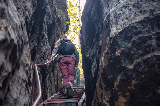 mulher sobe as escadas através de uma fenda nas rochas
 - Foto, Imagem