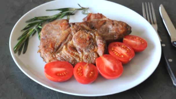 Жареные мясные стейки на тарелке с помидорами и розмарином и соусом
 - Кадры, видео