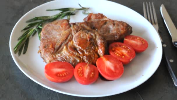 Жареные мясные стейки на тарелке с помидорами и розмарином и соусом
 - Кадры, видео