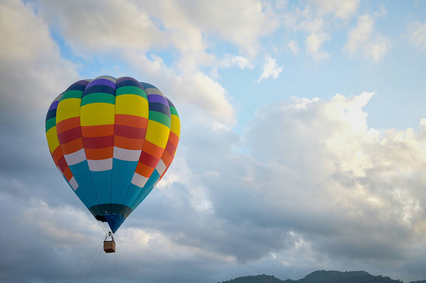Короткий воздушный шар летит в небе с облаками и горами
 - Фото, изображение