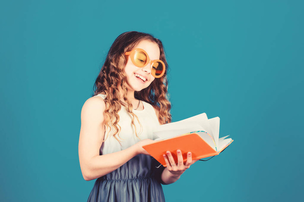 Hobby and leisure. Top funny books to read. Beach reads for summer. Kid likes reading book. Popular vacation books. Great books for summer vacation. Girl in sunglasses hold book. Summertime concept - Photo, image