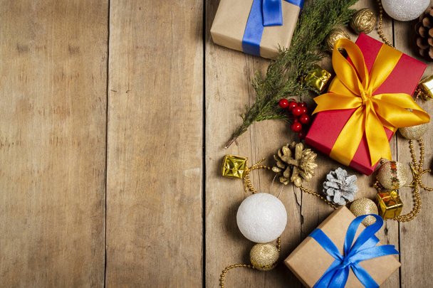Több ajándékdoboz, karácsonyi dekoráció, karácsonyfaág fából készült háttérrel. A karácsony, a téli ünnepek, az új év fogalma. Lapos fekvésű, felülnézet - Fotó, kép
