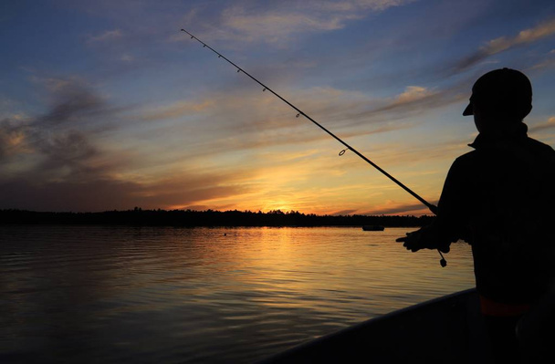 Coucher de soleil sur un ciel doré, comme on le voit sur les lacs sauvages du Canada. Pêche et esprit de vacances abondent, la beauté de la nature est appréciée et admirée. Liberté de l'âme et de l'esprit - Photo, image