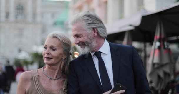 Glamorous senior couple walking to restaurant on luxury holiday - Кадры, видео