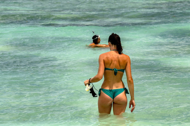 schöne Frau mit schwarzem Haar schwimmt im türkisfarbenen Wasserparadies - Foto, Bild