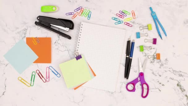 Colored papers for notes appear on the office table full with office supplies - Stop motion - Séquence, vidéo