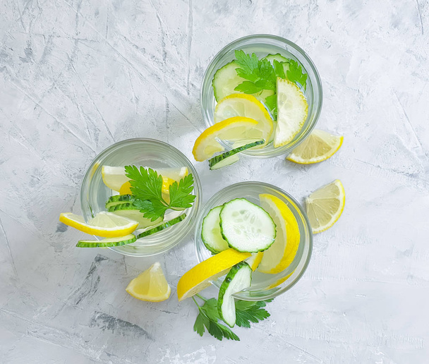 water with lemon, parsley on a concrete background - 写真・画像