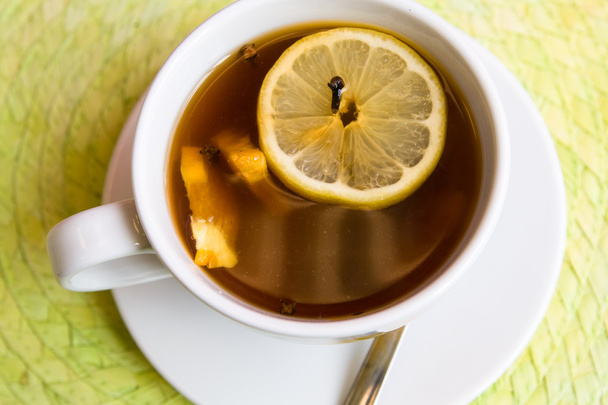 Tasty tea with cinnamon, cloves and lemon for breakfast - Fotoğraf, Görsel