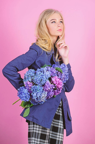 Must have concept. Clothes and accessory. Woman blonde hair posing coat with flowers bouquet. Fashionable coat. Girl fashion model wear coat for spring and autumn season. Trench coat fashion trend - Foto, afbeelding