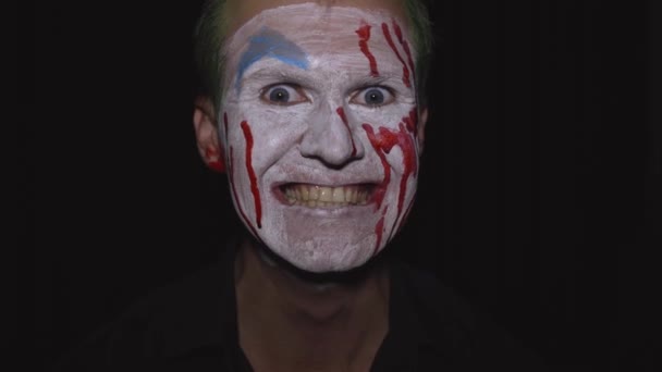 Portrét klauna Halloweena. Strašidelná, zlá klaunská krvavá tvář. Bílý make-up obličeje - Záběry, video