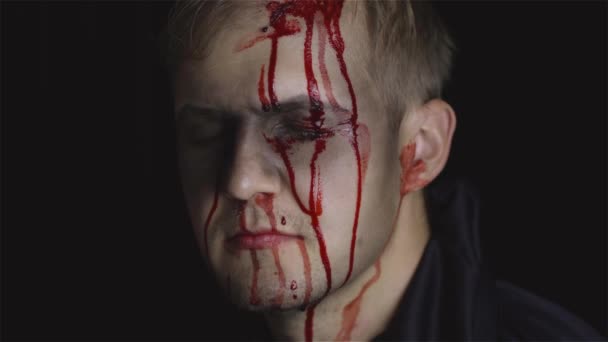 Retrato de Halloween. Un tipo con sangre goteando en su cara. Maquillaje aterrador
 - Metraje, vídeo