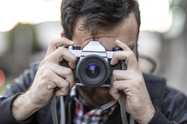 Photographer with beard and photographic camera outdoor. - Fotó, kép