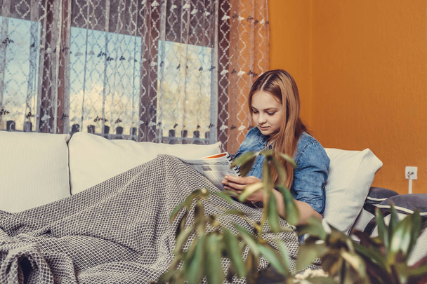 Скрытая девочка, сидящая на кровати, покрытой одеялом, и
 - Фото, изображение