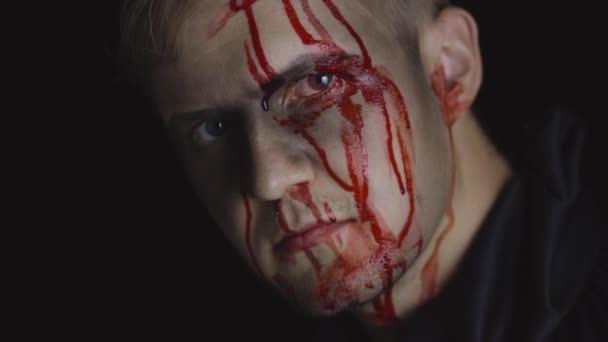 Halloween-Männerporträt. Kerl mit tropfendem Blut im Gesicht. Gruseliges Make-up - Filmmaterial, Video