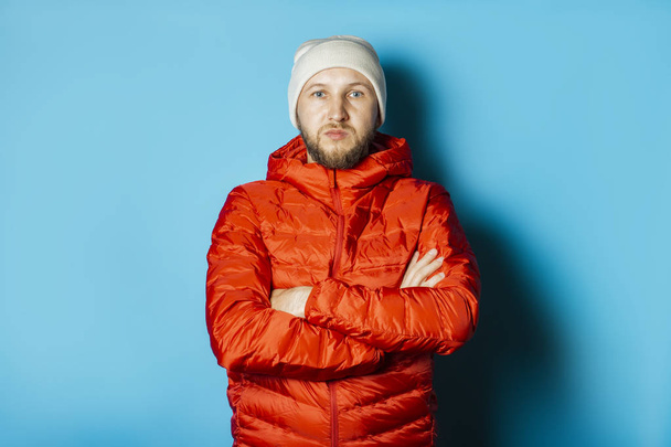 Hombre con los brazos cruzados en el pecho con un sombrero y una chaqueta roja
  - Foto, Imagen