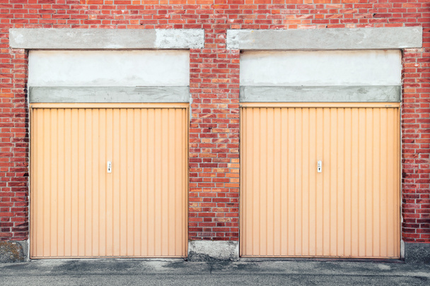 puertas de garaje cerradas, dos porticulis en la pared de Brik
 - Foto, Imagen