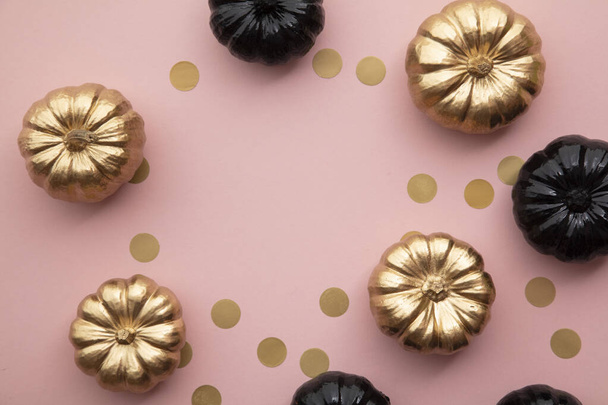 Gold and black pumpkins on pastel pink. Flat lay thanksgiving composition - Photo, Image