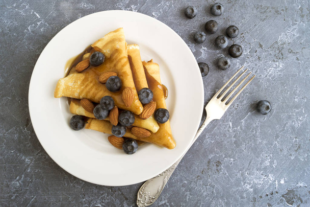 pancakes with syrup nuts and blueberries. on a white plate - Фото, зображення