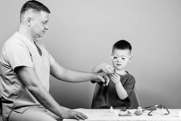 father and son in medical uniform. family doctor. medicine and health. happy child with father with stethoscope. small boy with dad in hospital. father and son concept. father and son play together - Zdjęcie, obraz