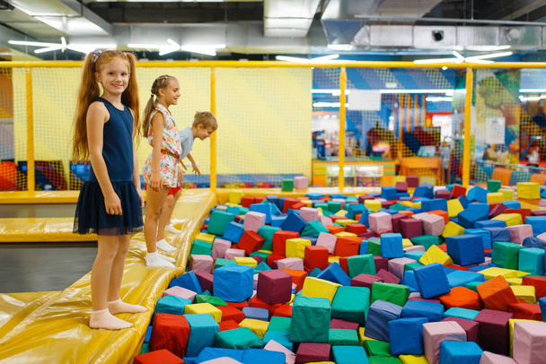 Nette Kinder springen auf Kinder-Trampolin, Spielplatz im Unterhaltungszentrum. Spielbereich drinnen, Spielzimmer - Foto, Bild