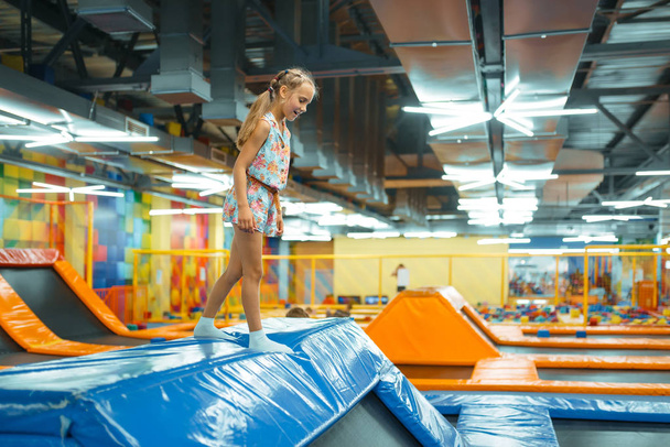 Rozkošná dívka skákání na děti trampolína, hřiště v zábavním centru. Hřiště uvnitř, herna - Fotografie, Obrázek