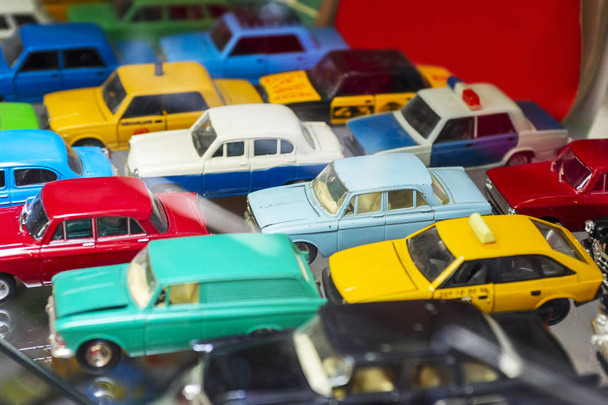 Big collection of retro car models on the shelf. Miniatures of colorful vintage vehicles in the shop. Selective focus - Фото, изображение