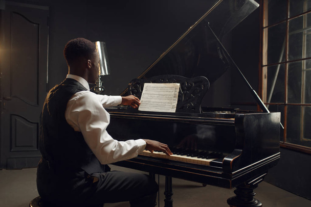 Afrikkalainen pianisti, jazz esiintyjä lavalla valonheittimet taustalla
.  - Valokuva, kuva