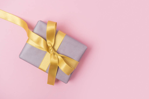 Fondo rosa navideño con regalo, lazo amarillo, cinta. Día de San Valentín, Feliz Día de la Mujer, Día de la Madre, Cumpleaños, Boda, Navidad
. - Foto, Imagen