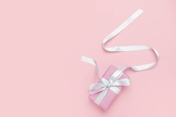 Holiday pink background with gift, white satin bow, ribbon. Valentine's Day, Happy Women's Day, Mother's Day, Birthday, Wedding, Christmas. - Foto, Imagem