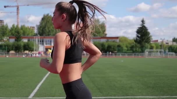 Karcsú nő fut a városi stadionban - Felvétel, videó