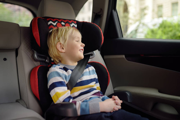 Portrait of pretty little boy sitting in car seat. Child transportation safety - Photo, Image