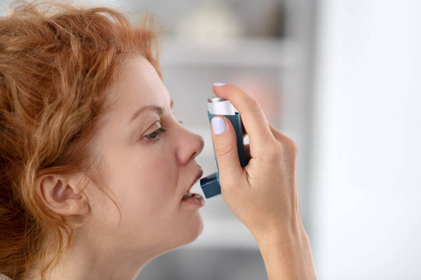 Woman using inhalator while having attack from asthma - Foto, immagini
