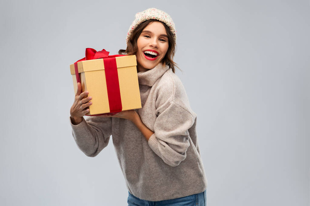 young woman in knitted winter hat holding gift box - Foto, immagini