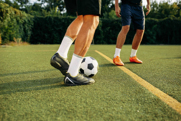 野球場では男子サッカー選手が球技をしている。屋外スタジアムでのサッカー、サッカー試合前のワークアウト - 写真・画像