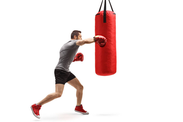 Young muscular man training box with a punching bag - Fotoğraf, Görsel