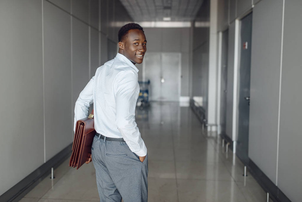 African businessman with briefcase in office hall.  - Foto, afbeelding