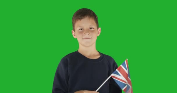 Büyük Britanya bayrağı taşıyan bir çocuğun portresi. Anahtar için yeşil ekran hromakey arkaplanı. - Video, Çekim