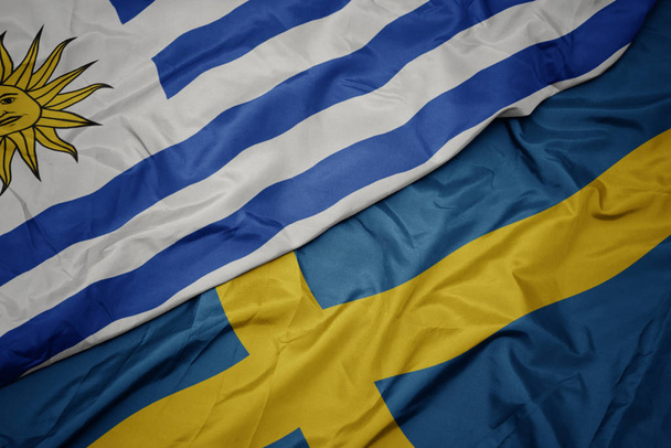 schwenken bunte schwedische und uruguayische Nationalflagge. - Foto, Bild